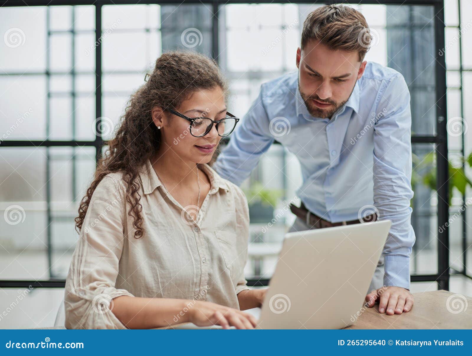 business lady looking at laptop with her colleague in the office