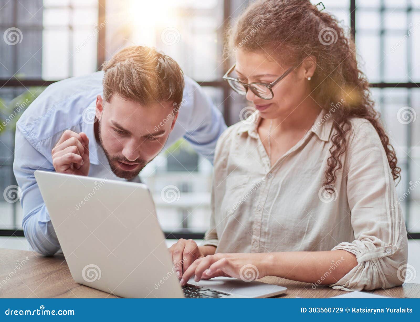 business lady looking at laptop with her colleague in the office