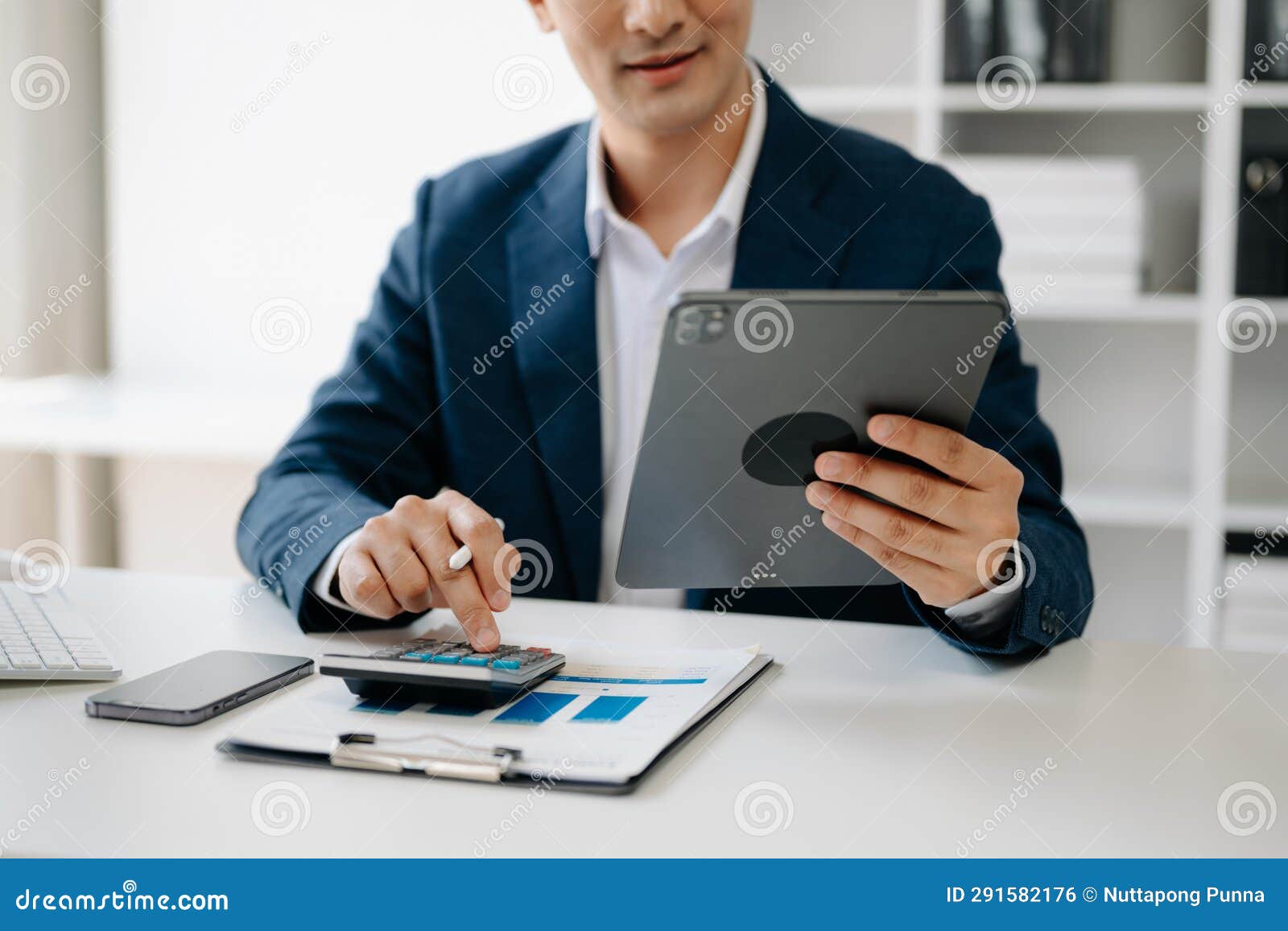 business man hands is typing on a laptop and holding smartphone at office