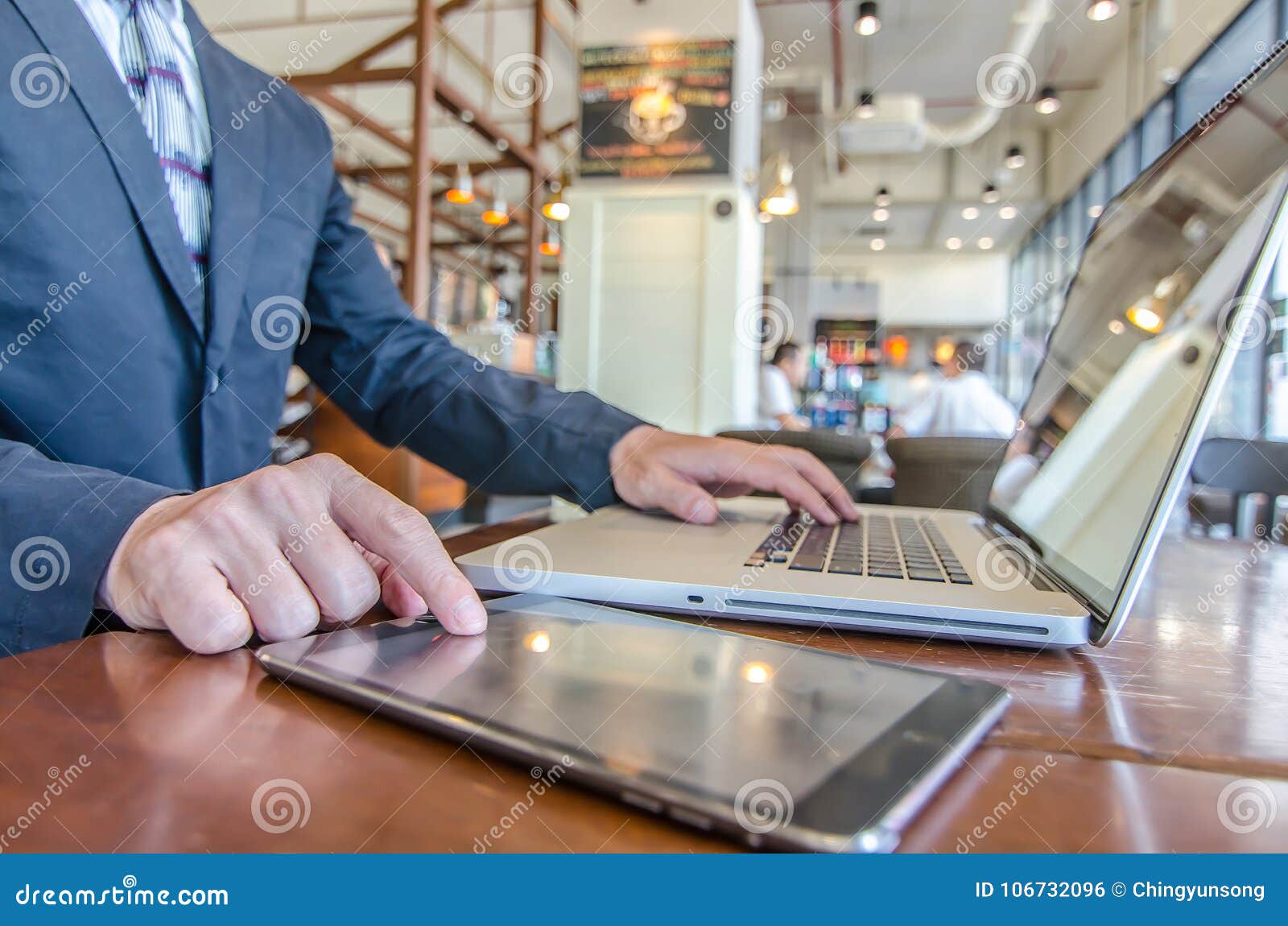business man working using ipad while working with laptop
