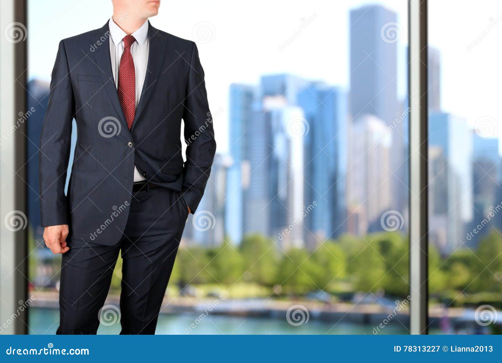 business and office concept - elegant young fashion buisness man in a blue/navy suit. downtown background behind