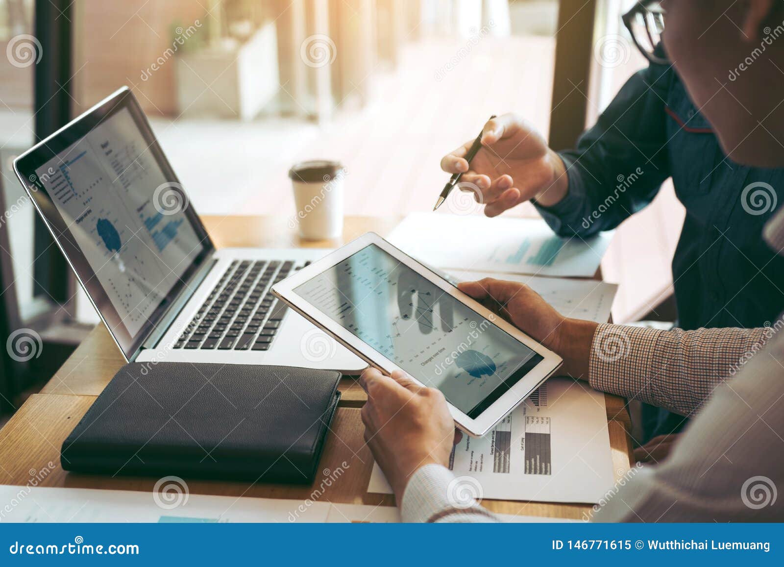 business partnership coworkers using a tablet to chart company financial statements report and profits work progress and planning