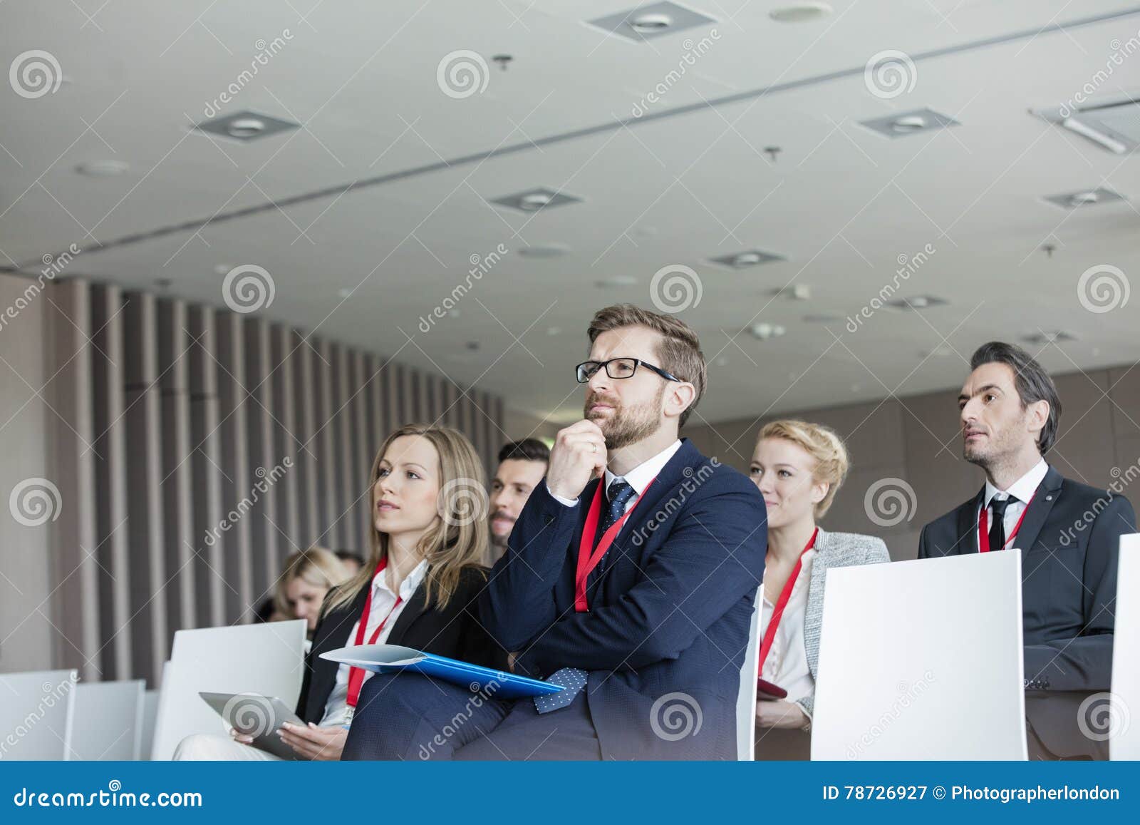 business people attending seminar in convention center