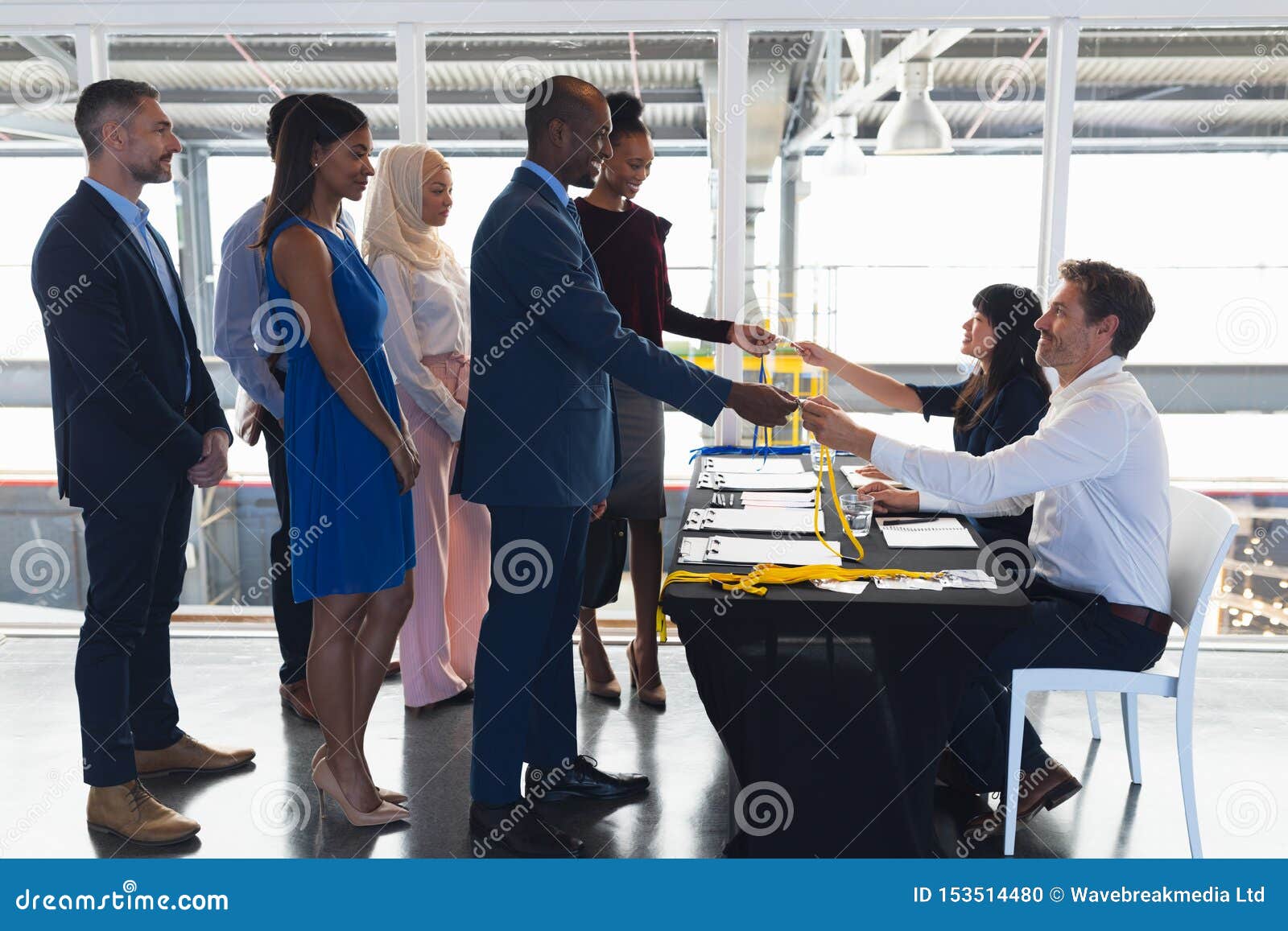 business people checking in at conference registration table