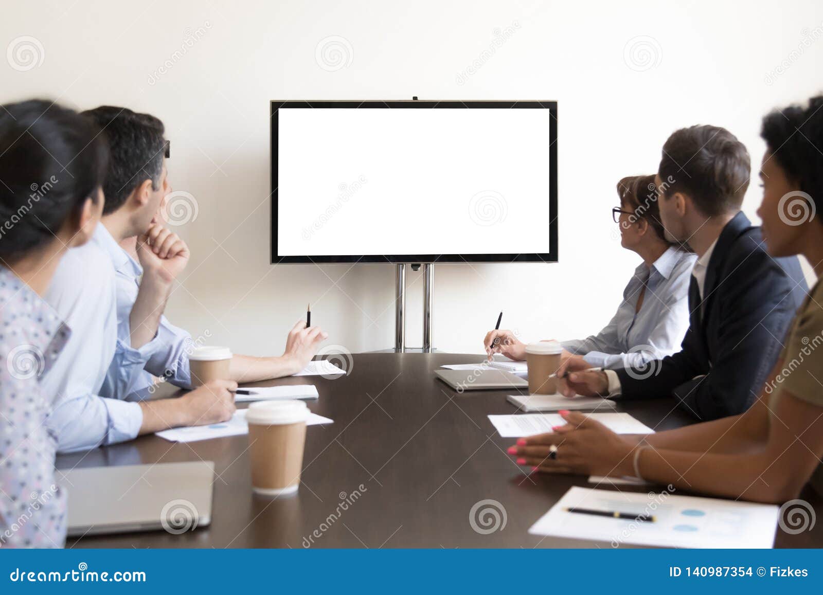 business people group sitting at conference table looking at screen