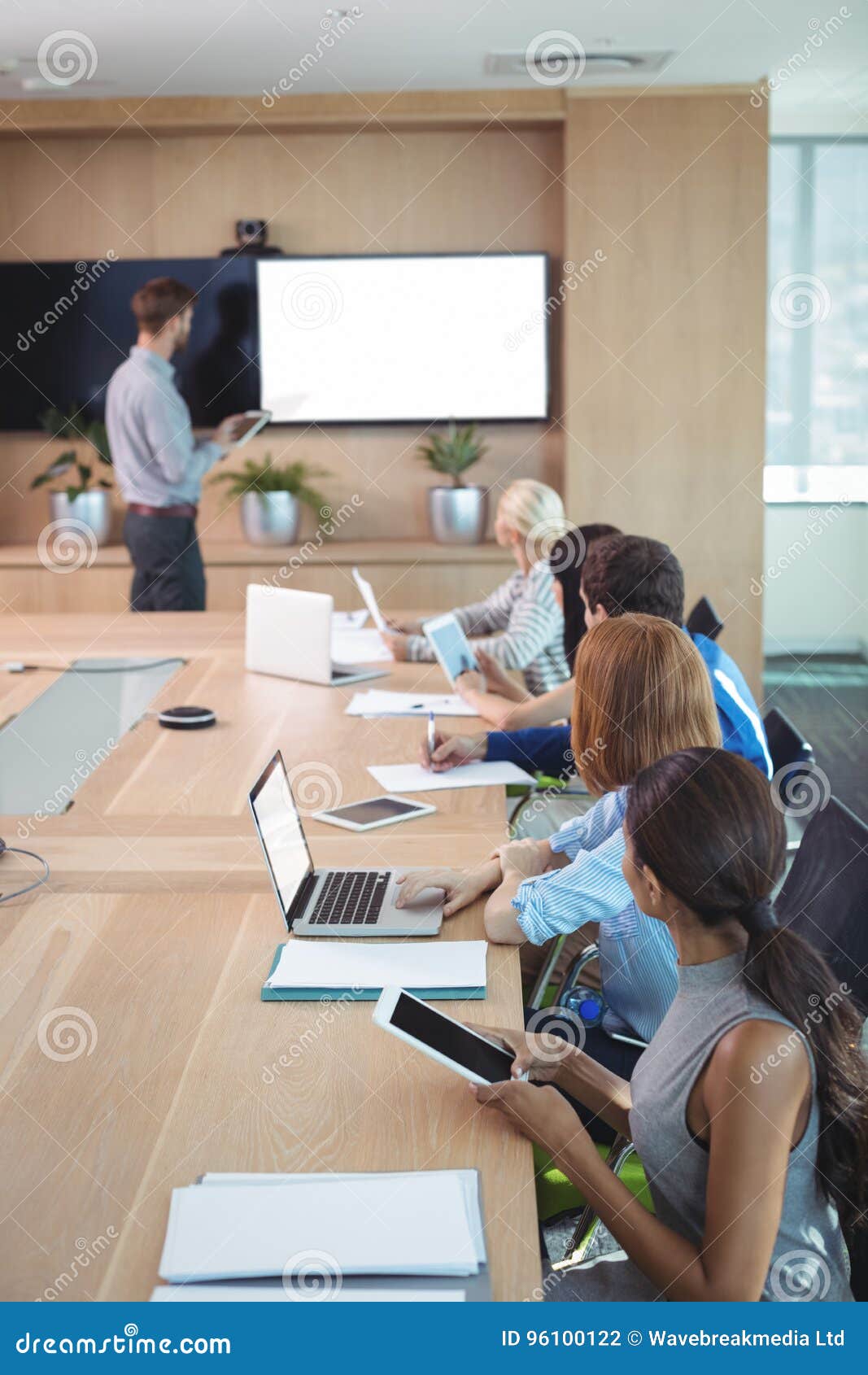 Business People Using Laptop and Digital Tablets at Conference Table