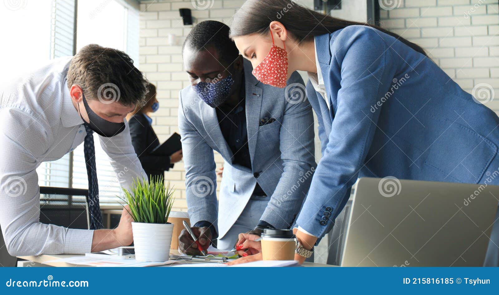 business people wear preventive masks during epidemy in office. collegues analysis finance growth