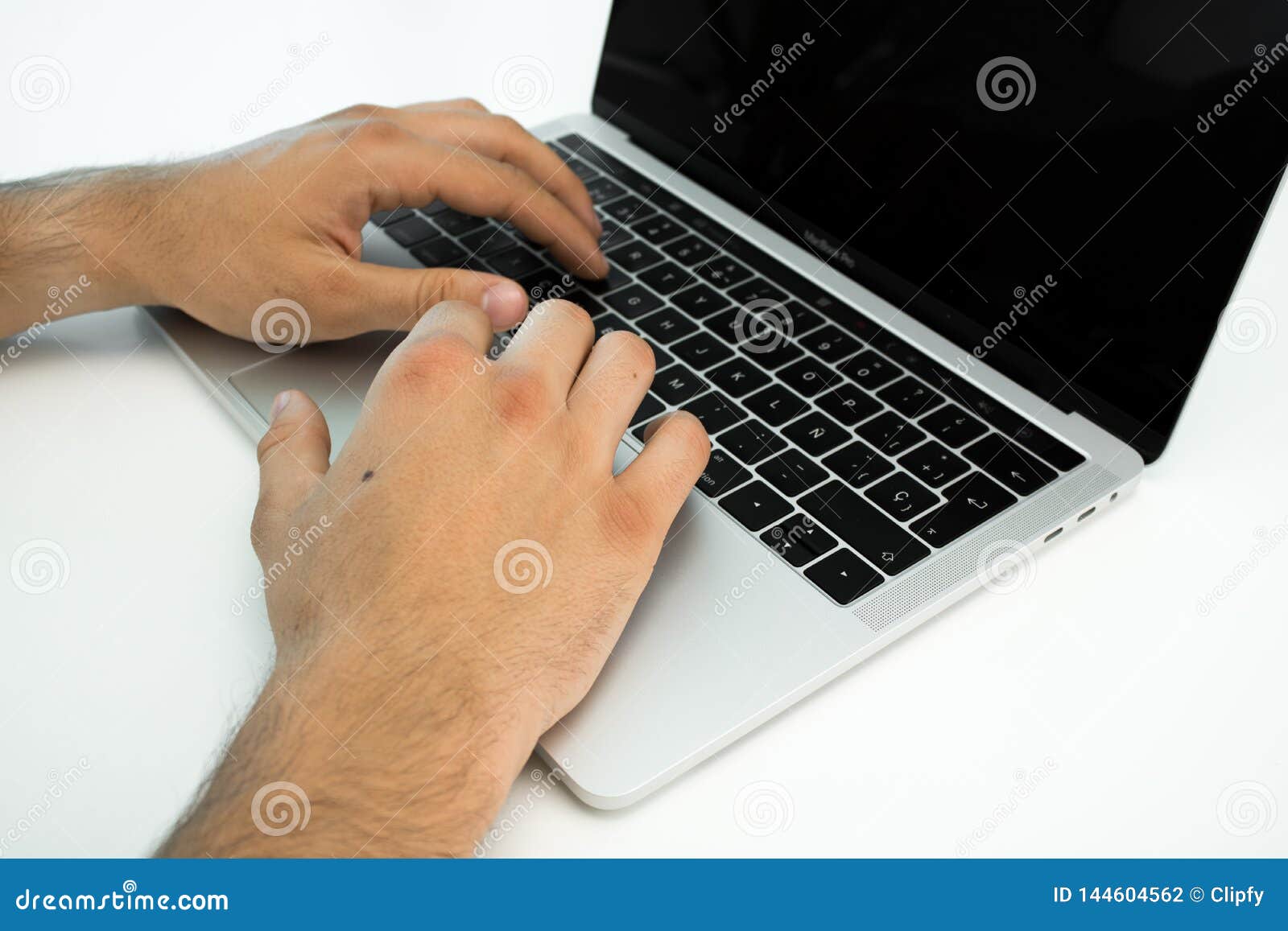 Business Person Using The Keyboard Of A Laptop On A White Table