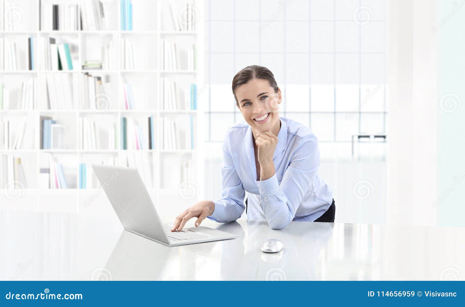 business smiling woman or a clerk working at her office desk wit