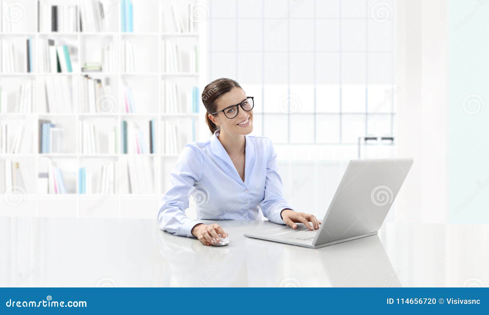 business smiling woman or a clerk working at her office desk wit