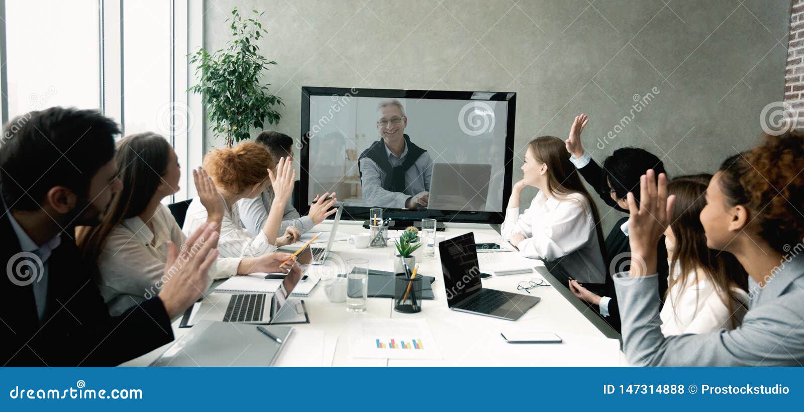business team having video call with senior boss at office