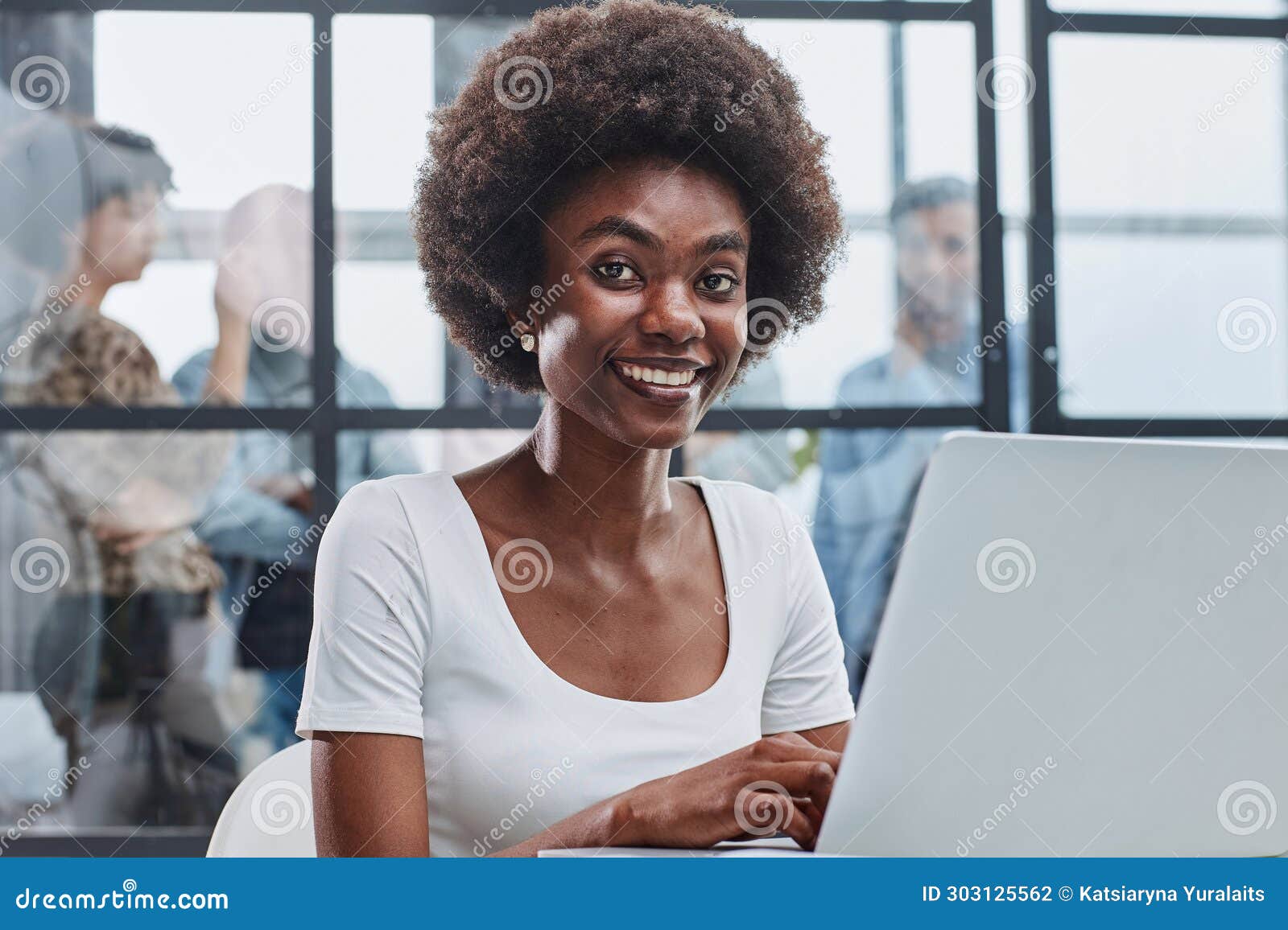 business woman with her staff in background at office