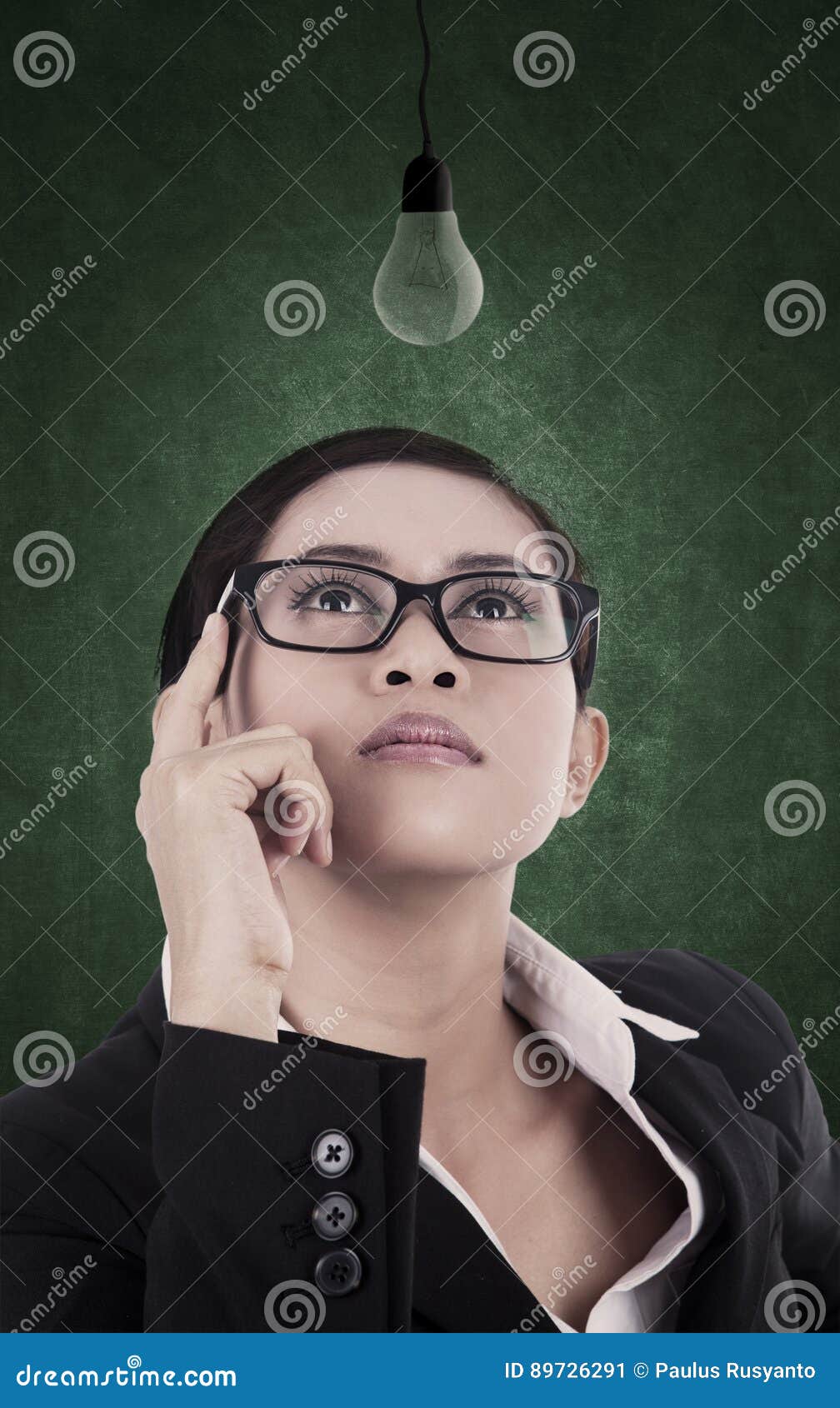 business woman looking at unlit light bulb