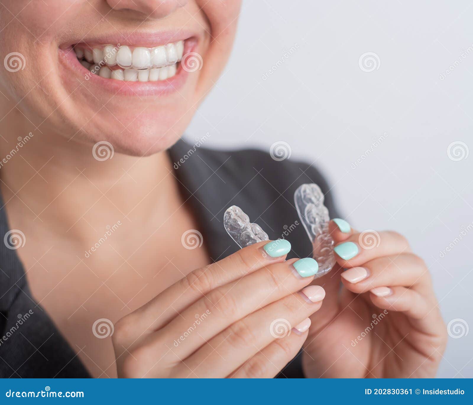 business woman puts on transparent retainers to straighten teeth