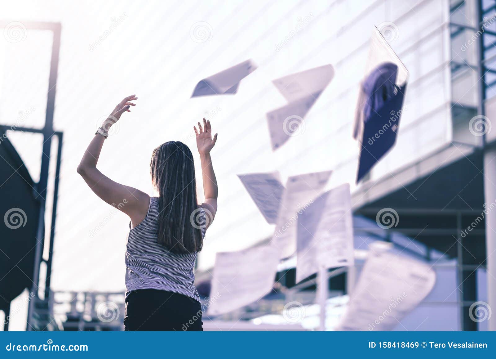 business woman throwing work papers in the air. stress from workload. person going home or leaving for vacation.