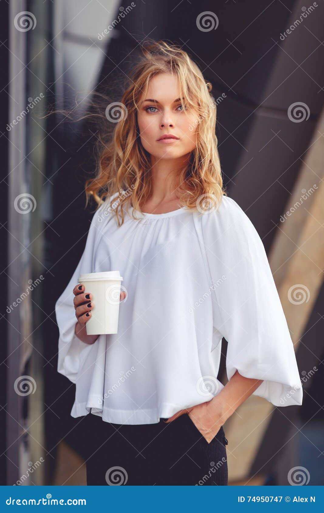 Business Woman With Wavy Blonde Hair Holding Coffee Stock Image