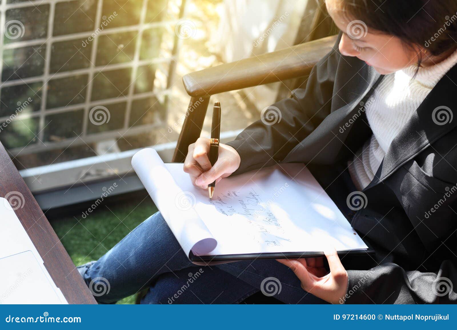 business woman writing on clipboard outside on terrace,on top view.