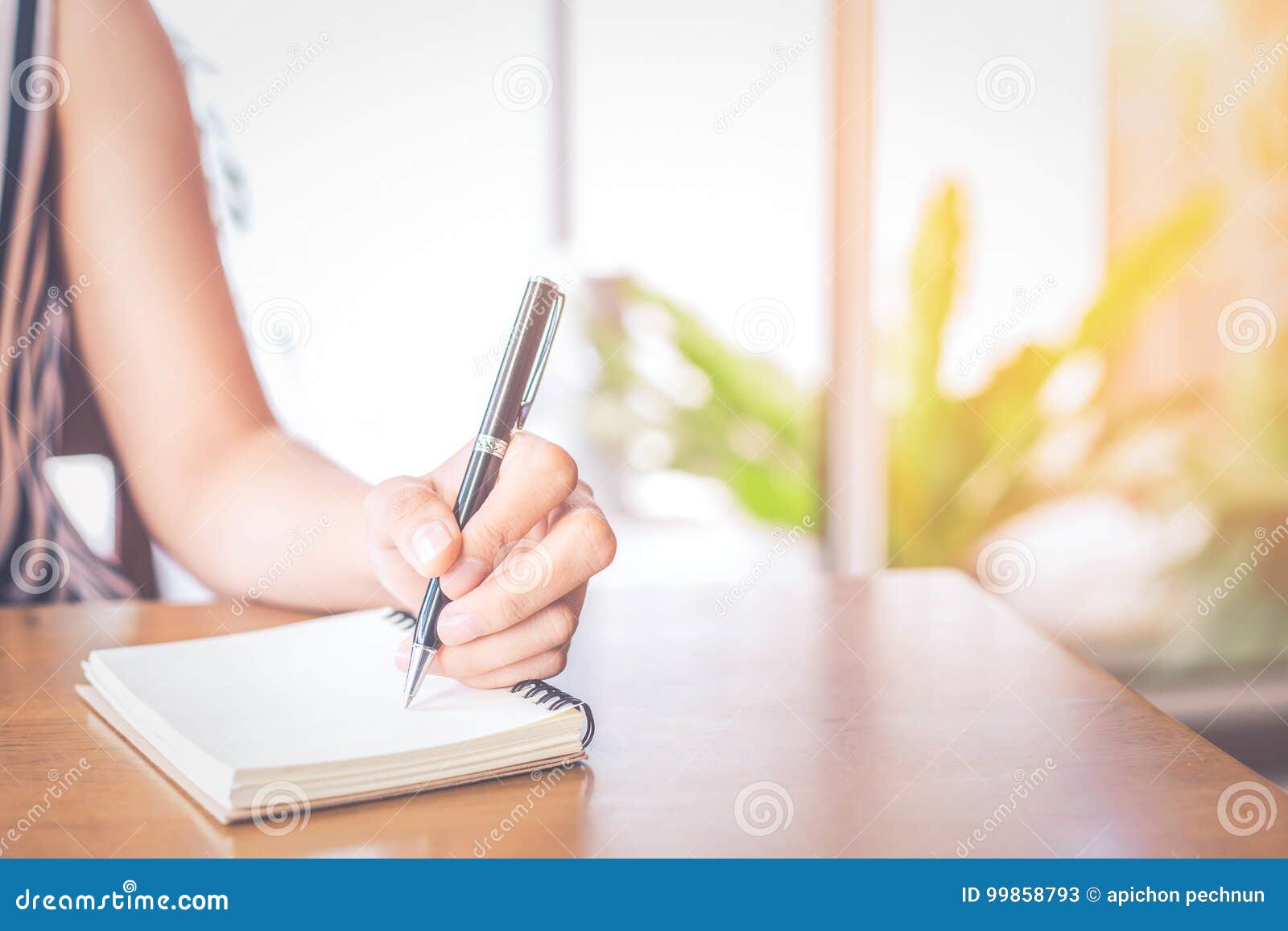 Business Women Hand Writing on a Notepad with a Pen on a Wooden Stock ...