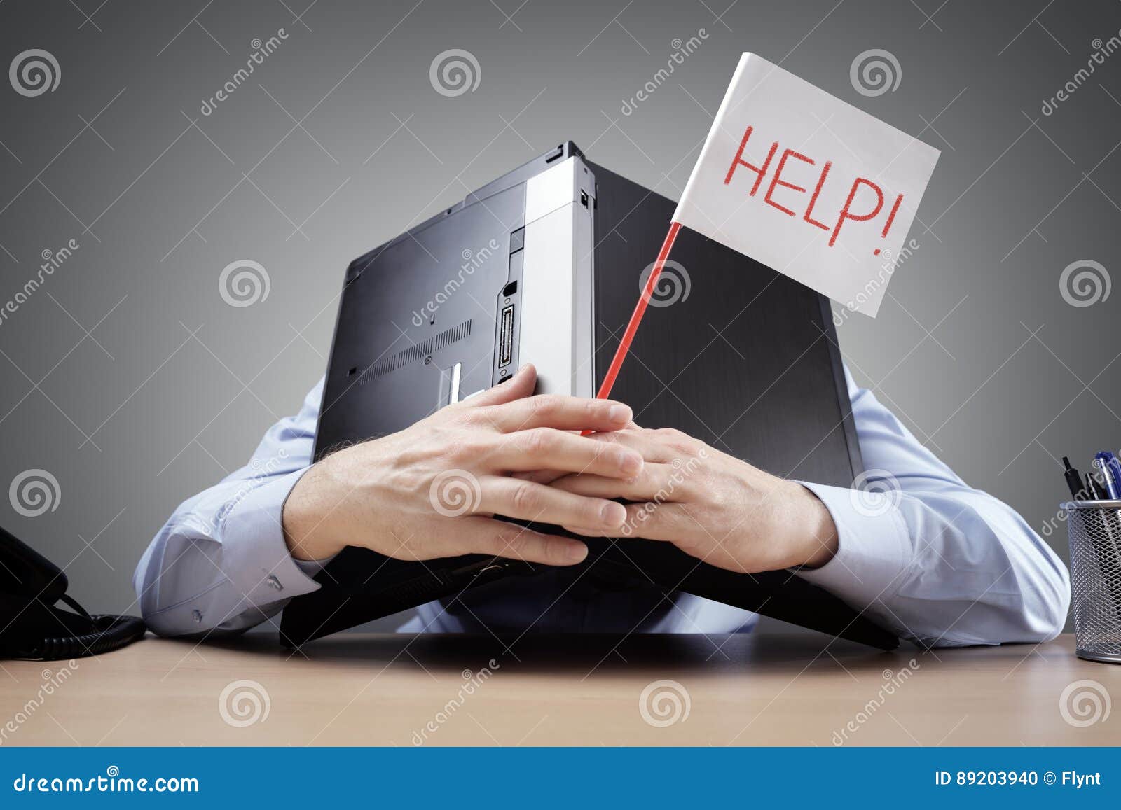 businessman burying his head under a laptop asking for help