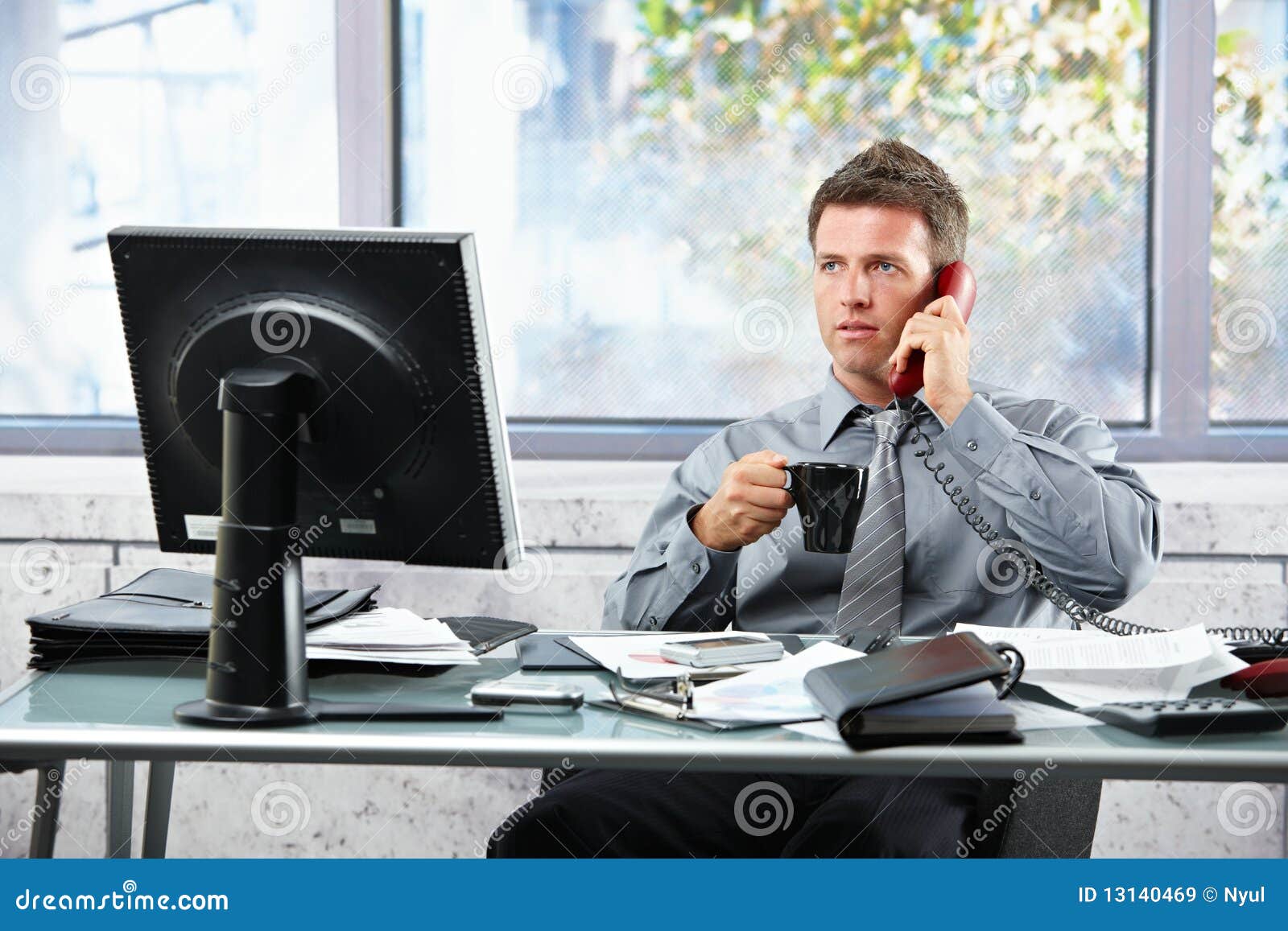 Businessman Calling At Office With Businessman Calling At Office With Mug Royalty Free Stock