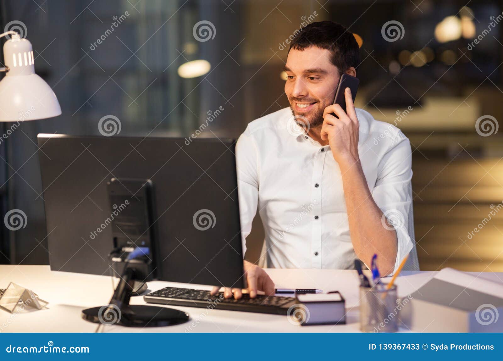 Businessman Calling On Smartphone At Night Office Stock