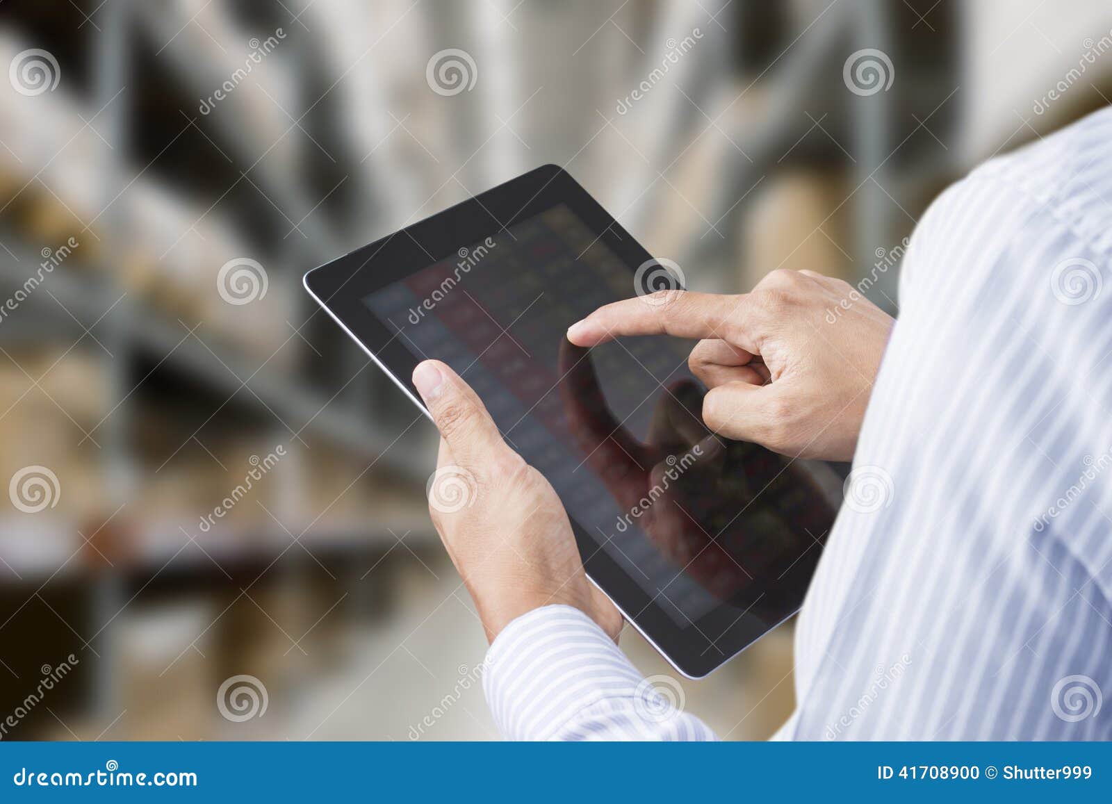businessman checking inventory in stock room of a manufacturing company on tablet