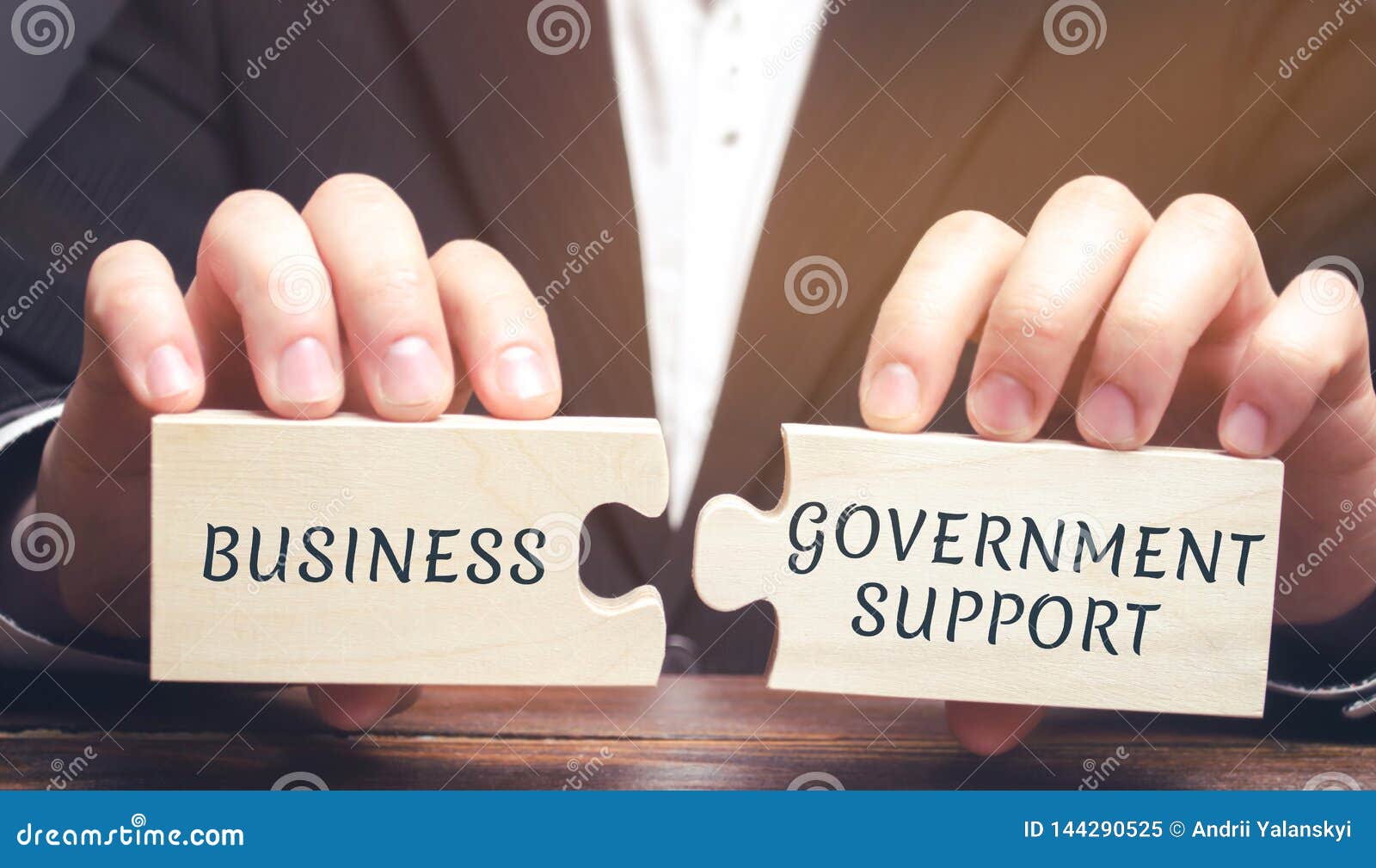 businessman collects puzzles with the words business and government support. tax relief. protection of manufacturers in the