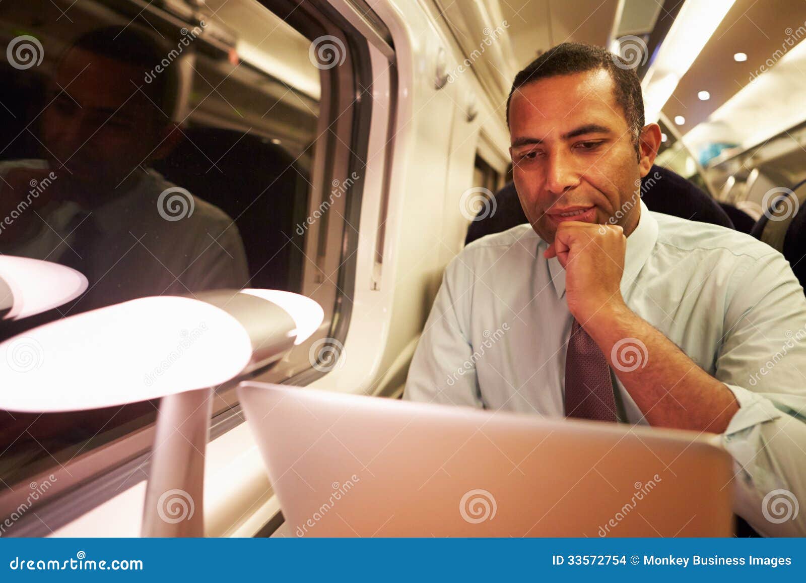 businessman commuting to work on train and using laptop