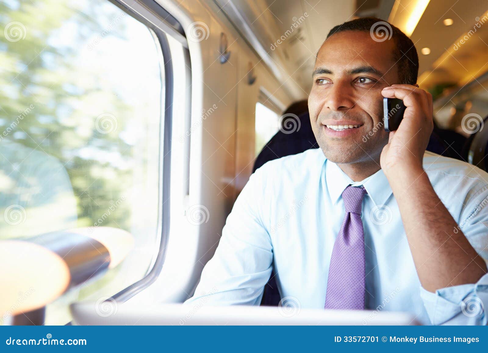 businessman commuting to work on train using mobile phone