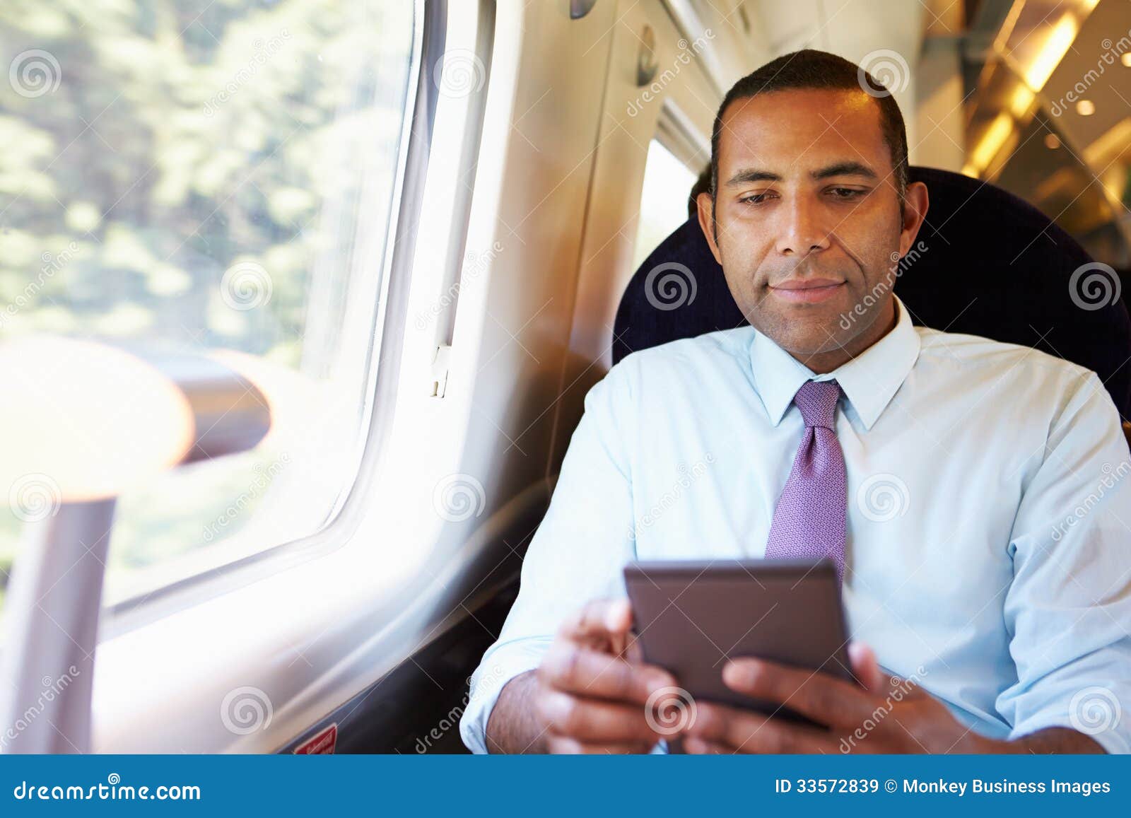businessman commuting on train reading a book