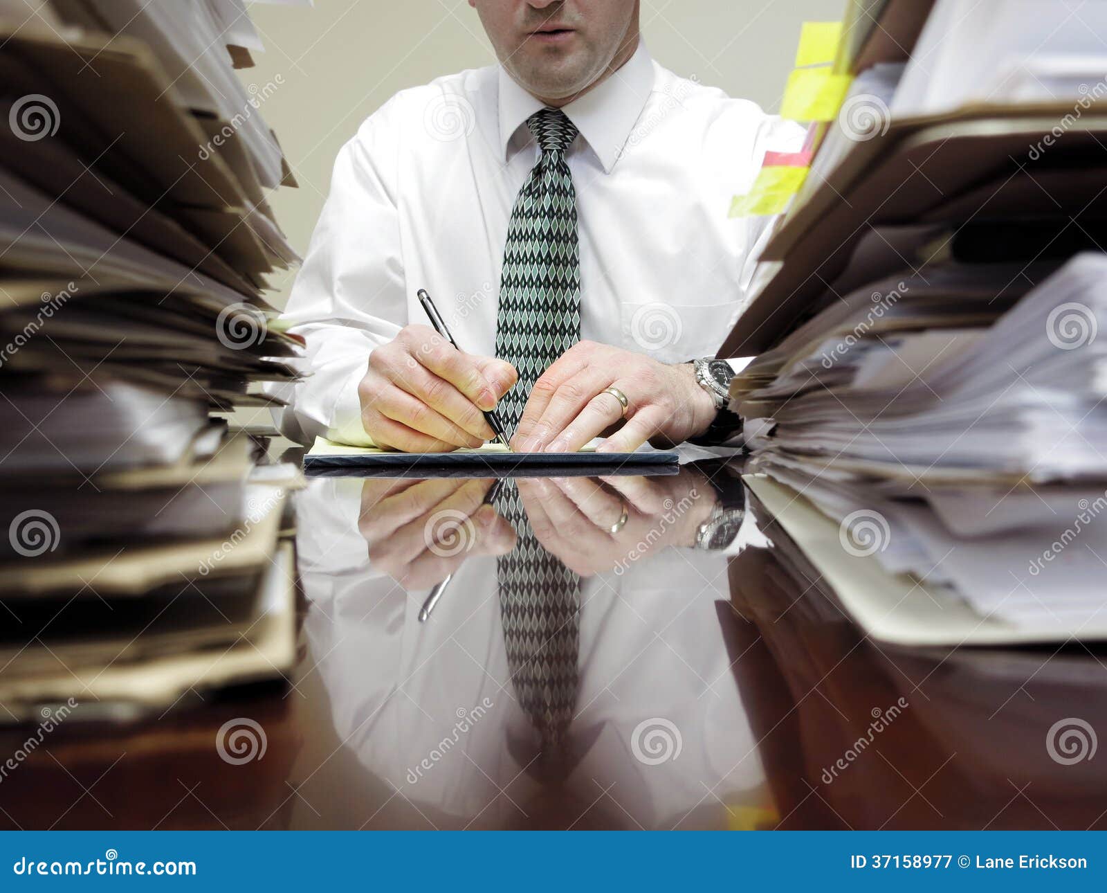 businessman at desk with piles of files