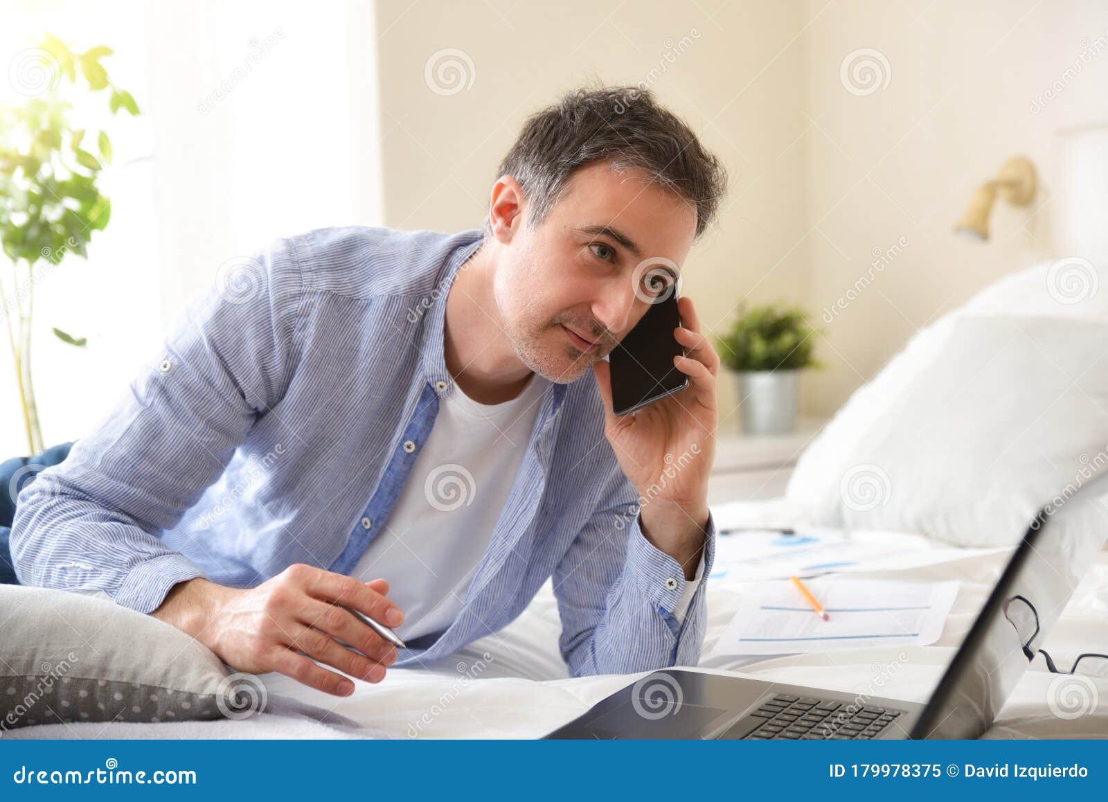 businessman working with a laptop lying on bed close up