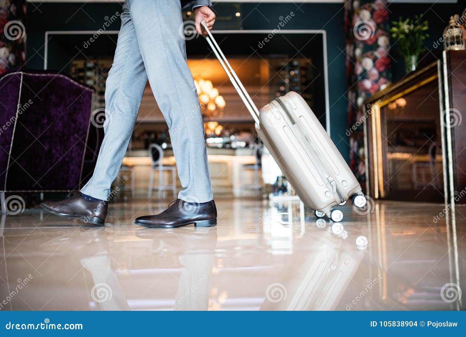 businessman entering hotel with luggage.