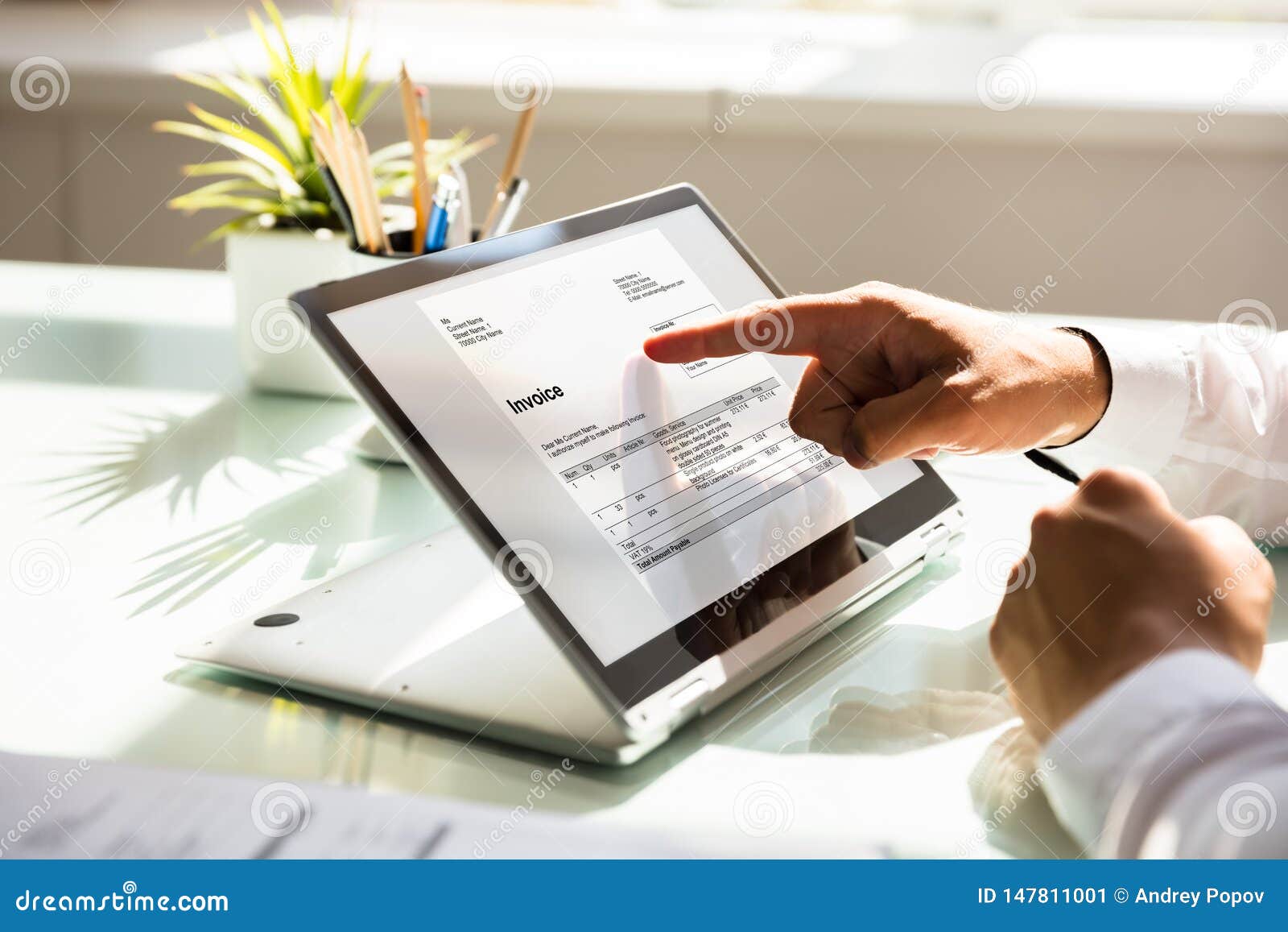 businessman examining invoice on laptop