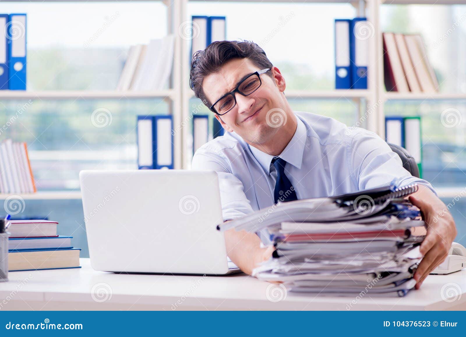 the businessman with excessive work paperwork working in office