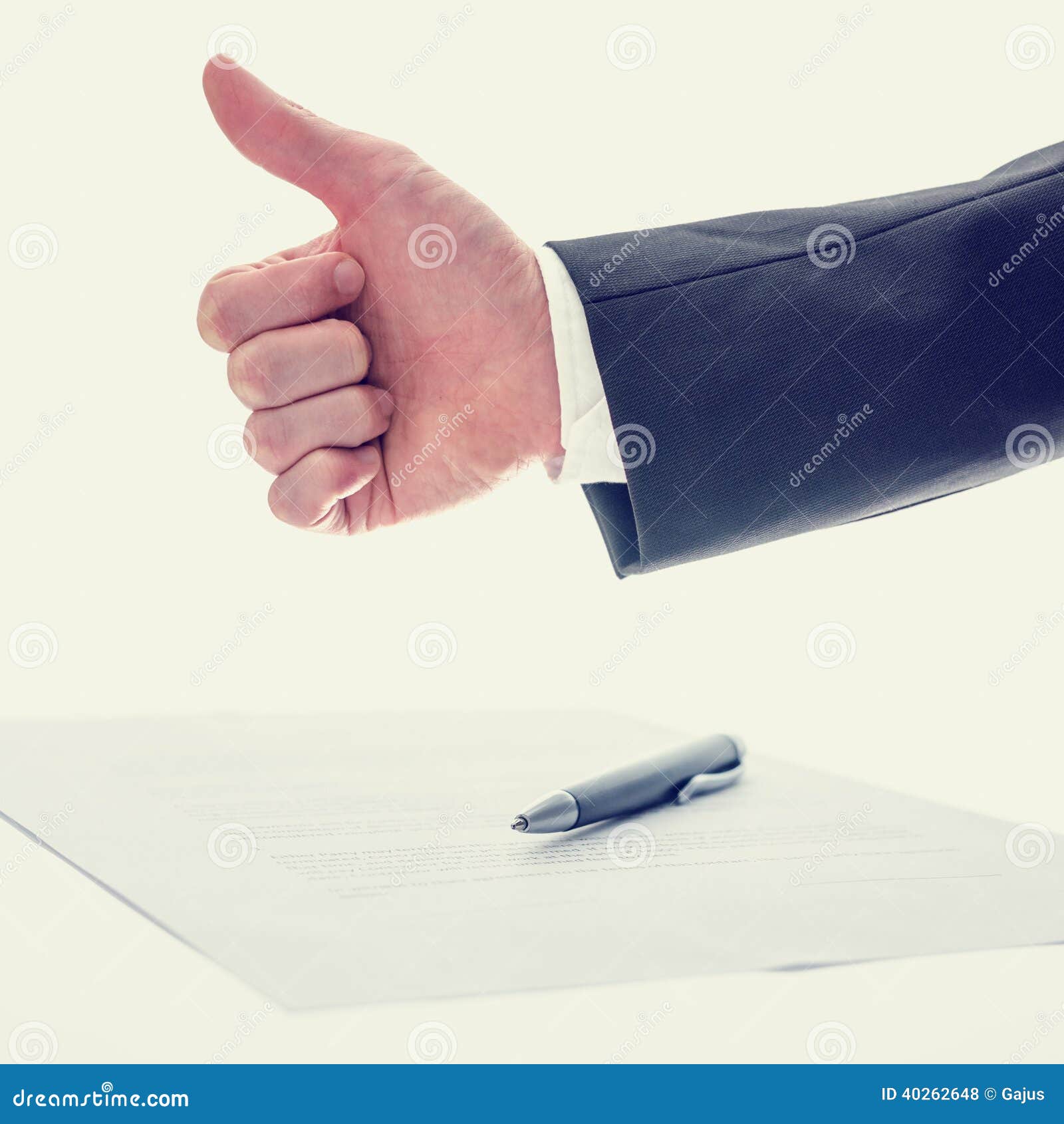 Retro vintage effect image of the arm of a businessman giving a thumbs up gesture of approval , success and agreement with a document and pen below conceptual of a business deal.