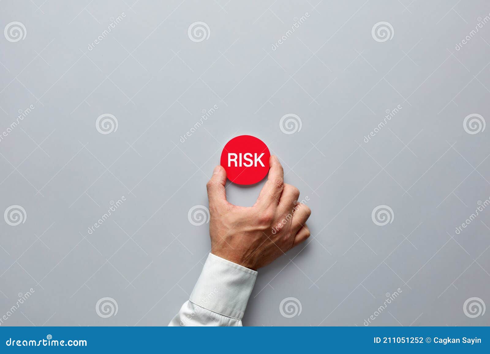 Businessman Hand Holding a Red Badge with the Word Risk. Risk