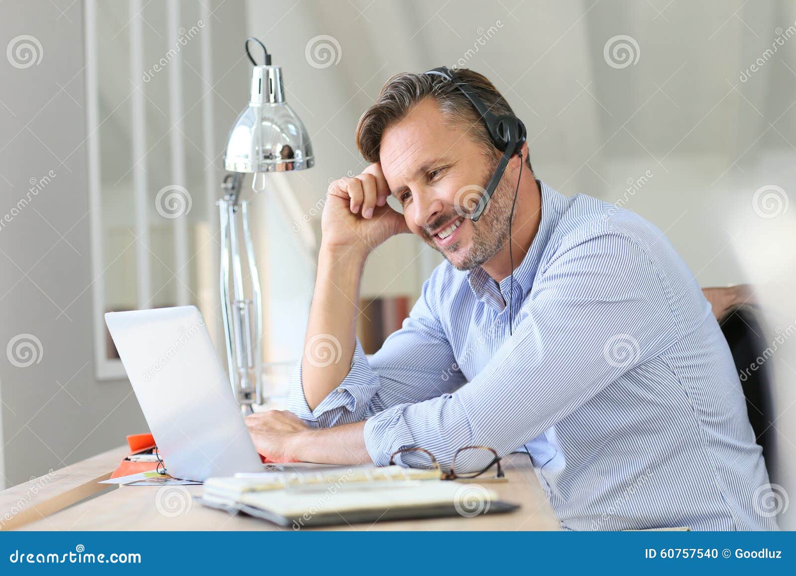 businessman with headset teleworking on laptop