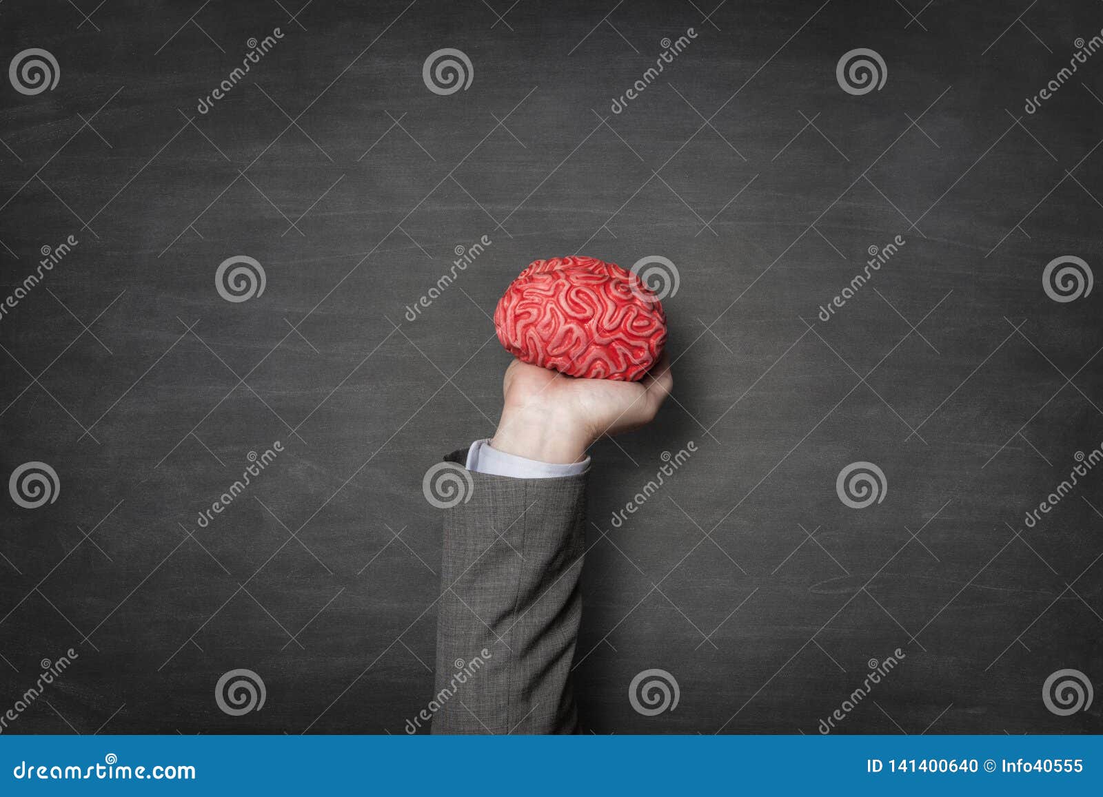 businessman holding red toy brains