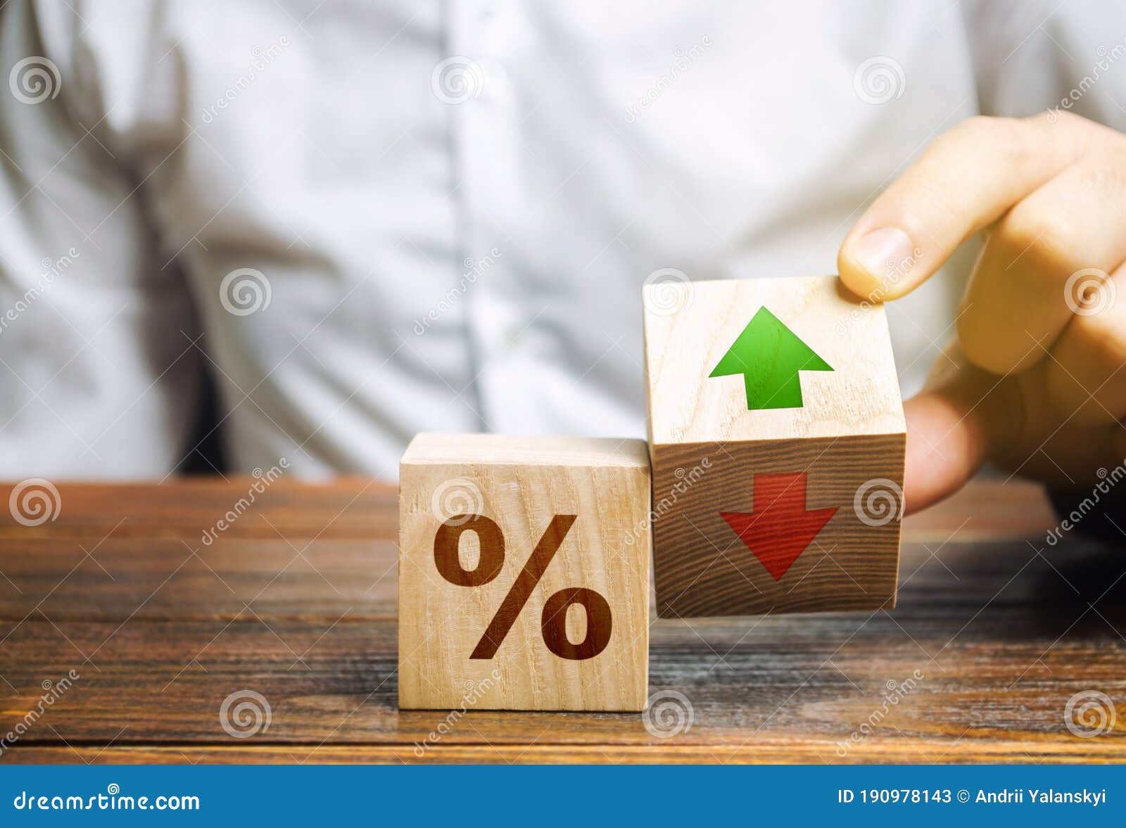 businessman holds wooden blocks with percent and up or down arrow. mortgage and loan rates. interest rate, stocks, ranking.