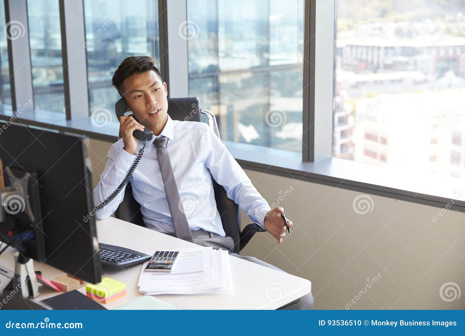 Businessman Making Phone Call Sitting at Desk in Office Stock Photo Image of horizontal