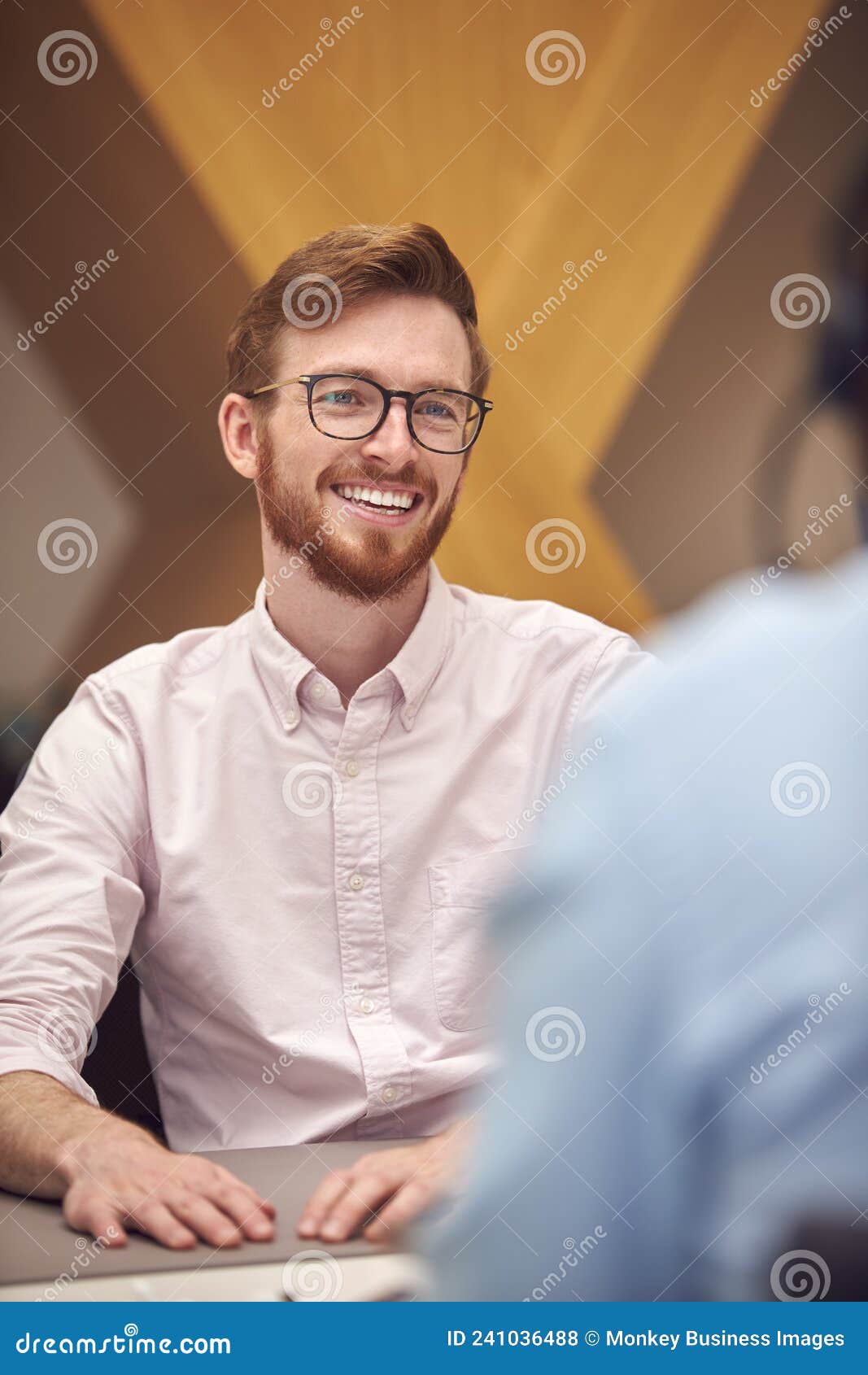 Businessman in Office Talking To Male Colleague Sitting at Desk Stock ...