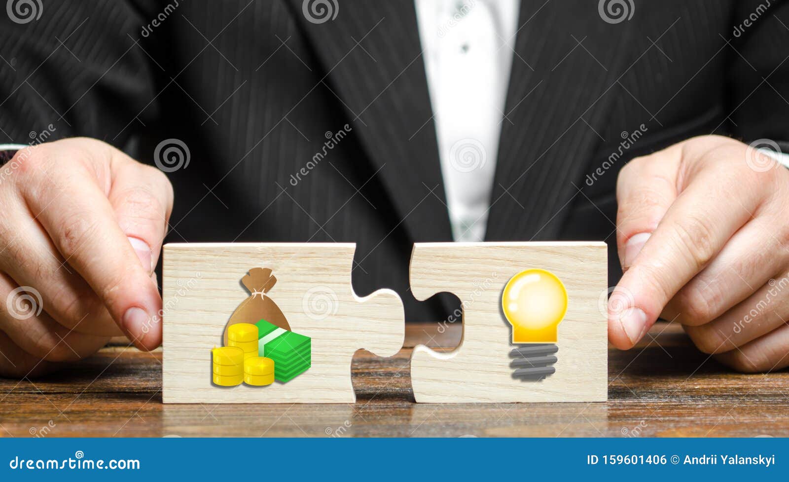 businessman puts two puzzles with the image of money and an idea bulb. financing promising startups and crowdfunding