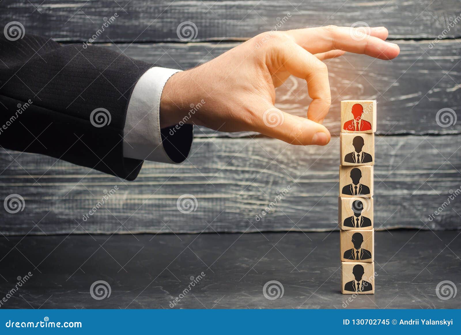 the businessman removes / dismisses the employee from the team. management within the team. wooden blocks with a picture of worker
