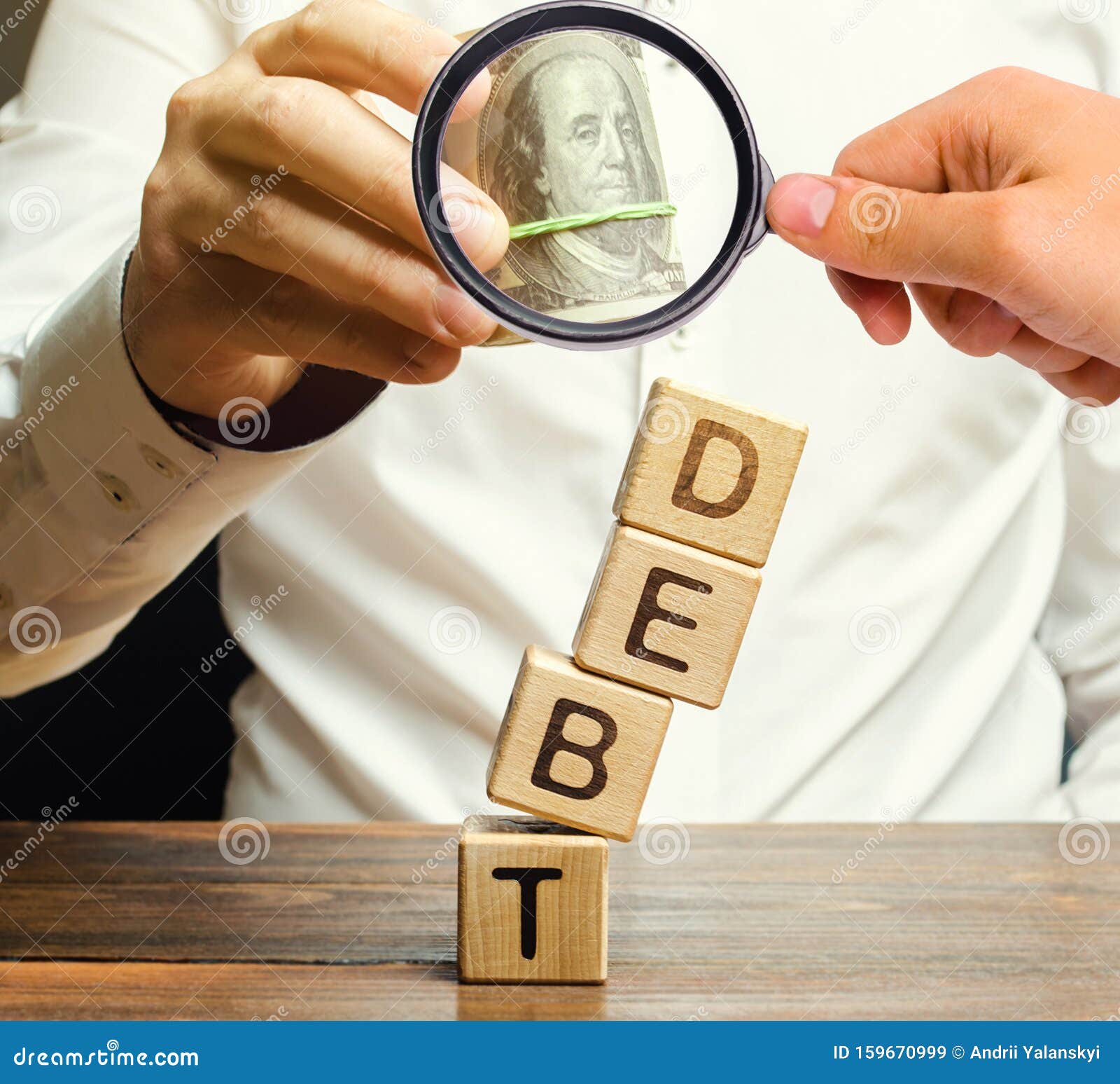 businessman removes wooden blocks with the word debt. debt relief or cancellation is the partial or total forgiveness of debts, or