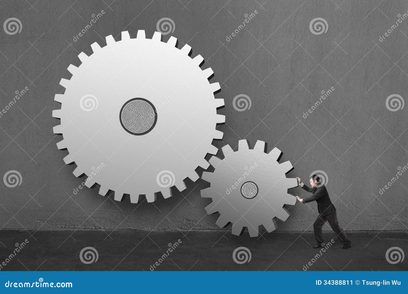 Businessman Rolling Large Concrete Gears in Concrete Wall Background