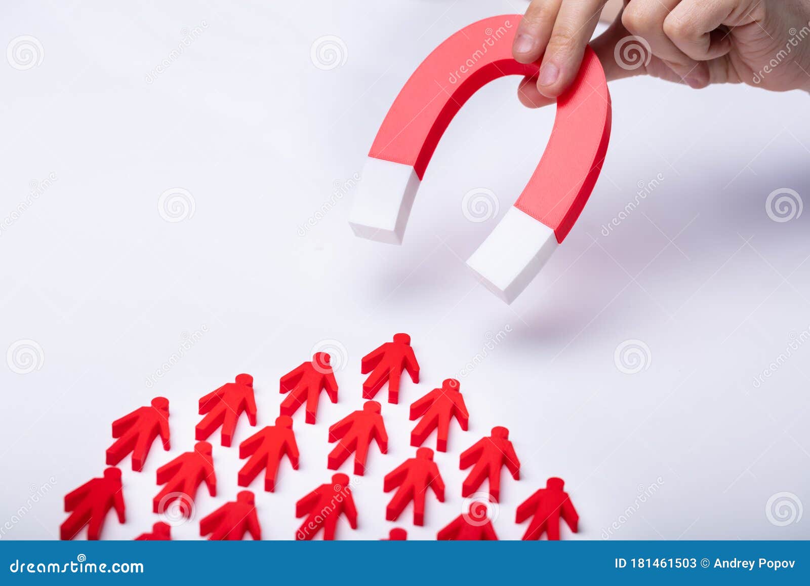 businessman attracting red team with horseshoe magnet