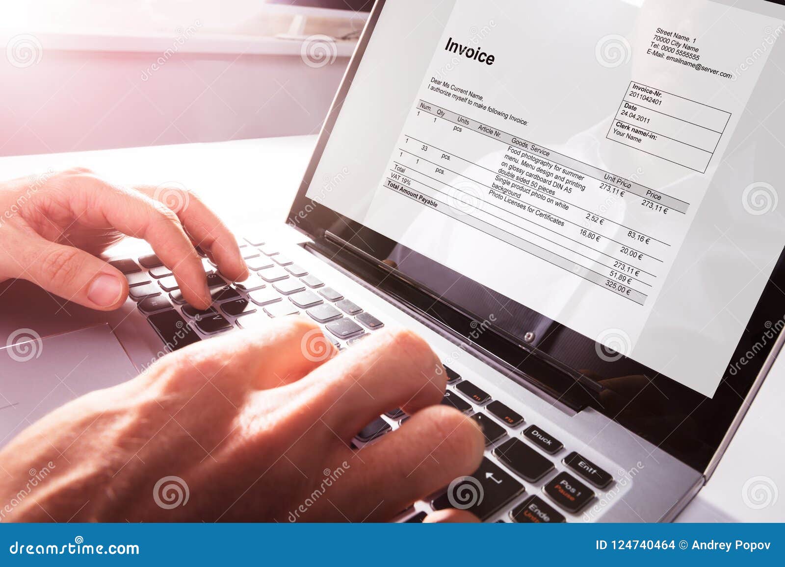 businessman`s hands working on invoice on laptop