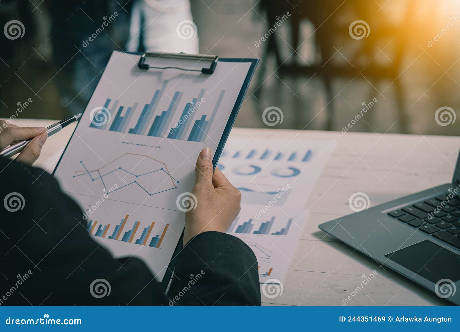 a businessman sitting at a table analyzing a financial chart with a pen in hand accountants work with data sheets that are calcula
