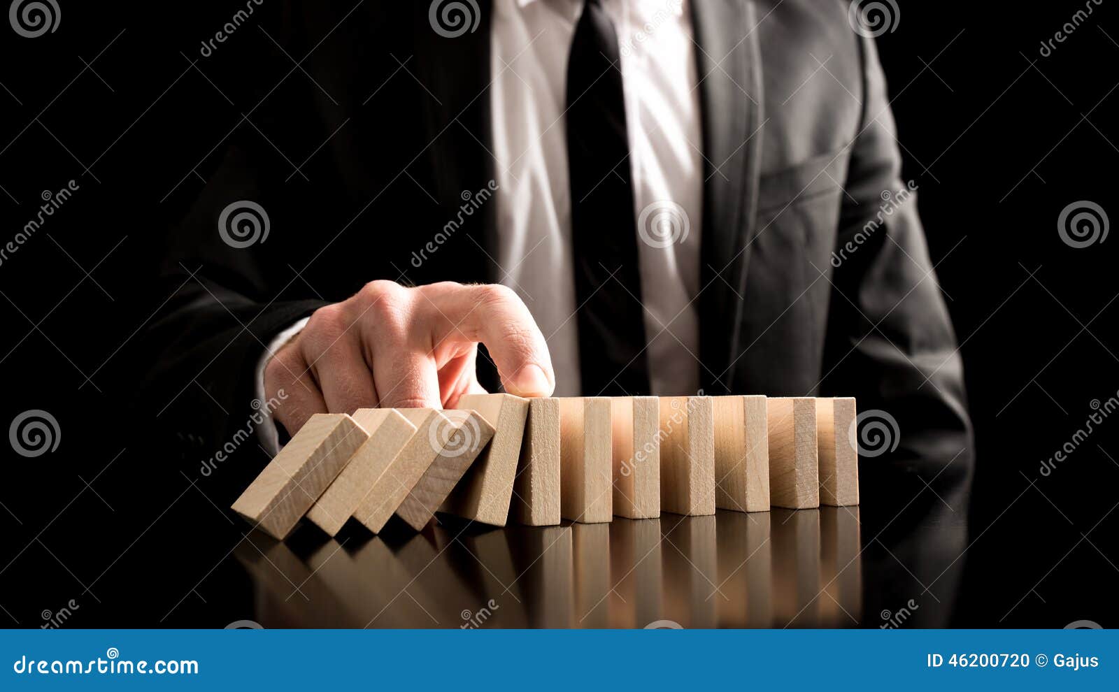 businessman stopping the domino effect